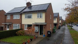 A typical UK semi-detached house with rooftop solar and domestic battery storage, used to explain Warm Homes Loan Scheme upgrades.