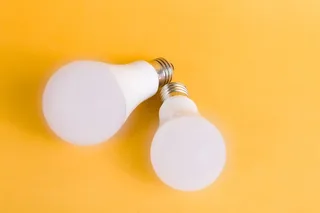 Two LED light bulbs on a bright yellow background, emphasizing modern energy-efficient lighting.